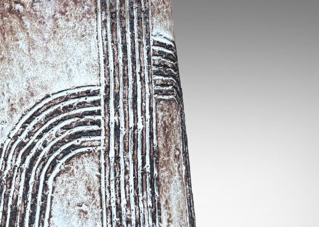 Gallery BAC squared bulb form with attenuated neck and carved concentric drop design, glazed in pale gray-tan and brown