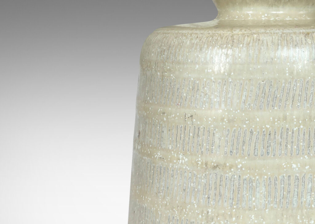 Gallery BAC upwardly tapered cylindrical form with bands of carved strikes; glazed in a dappled oyster / pale gray