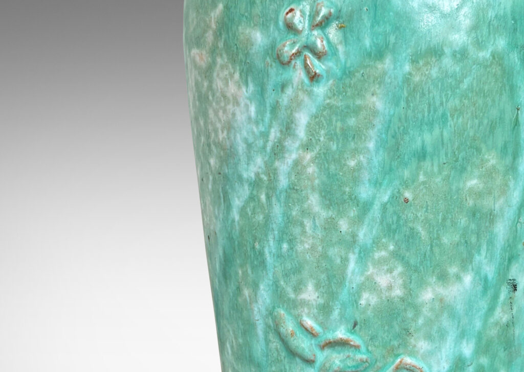 Gallery BAC tall tapered form with floating floral motifs in relief, glazed in a flowing bright celadon green