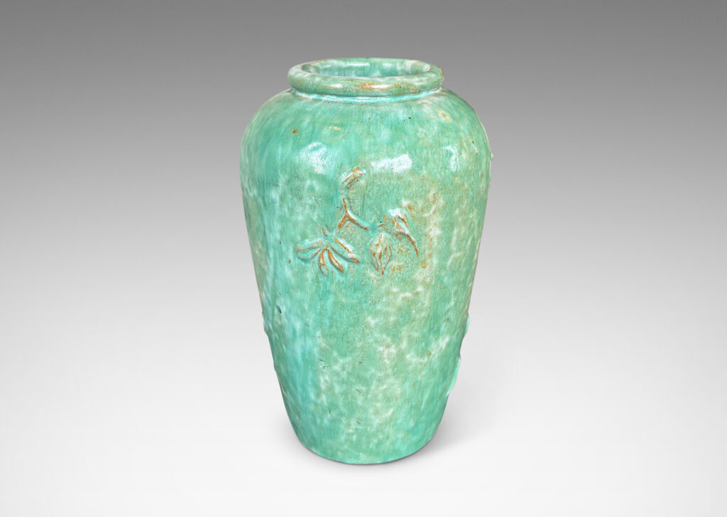 Gallery BAC tall tapered form with floating floral motifs in relief, glazed in a flowing bright celadon green