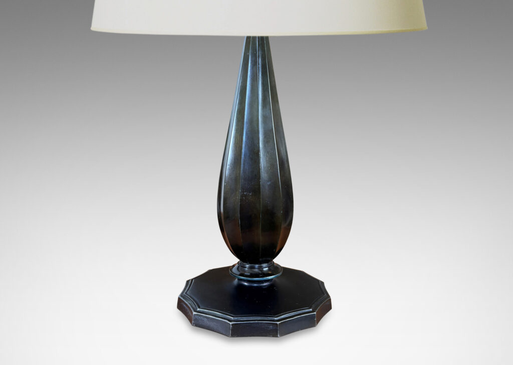 Gallery BAC fluted drop forms on disk plinths with fluted edges, finished in dark bronze tones