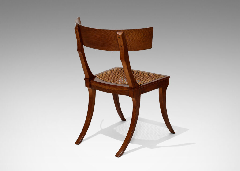 Gallery BAC curved back rail, springing sabered legs, and a hand-caned seat; solid oak