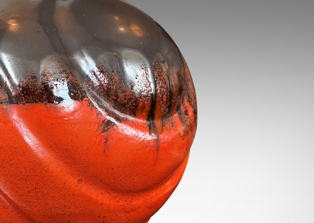 Gallery BAC diagonally lobed globe form, glazed orange overglazed on top with gunmetal gray