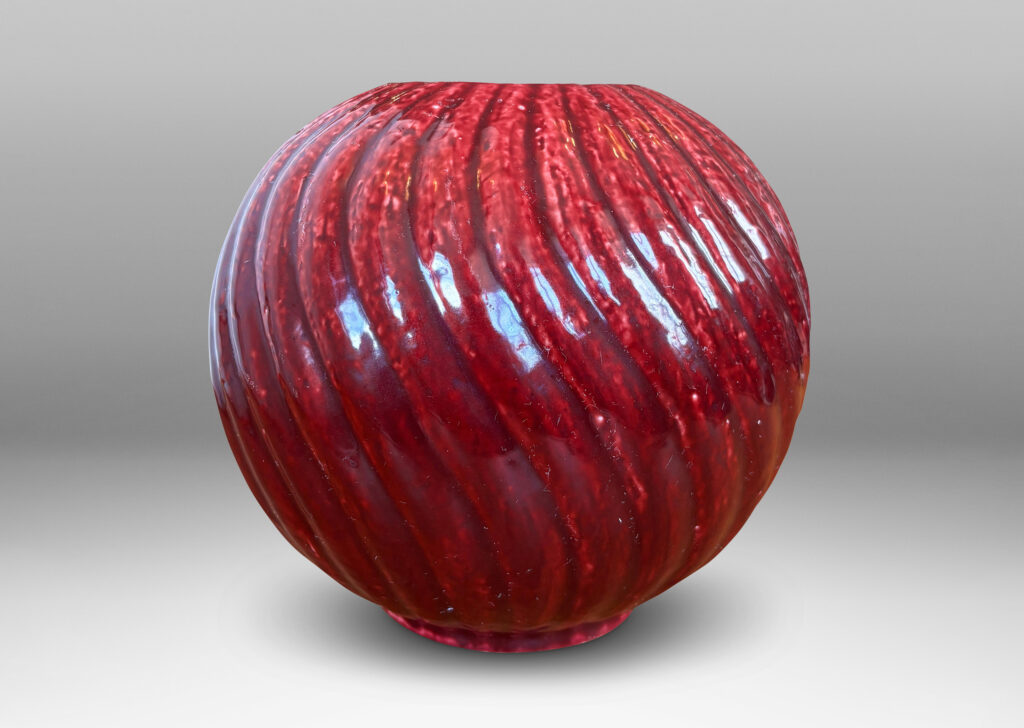 Gallery BAC globe form with spiraling vertical ribbing, in textured chamotte with a burgundy glaze