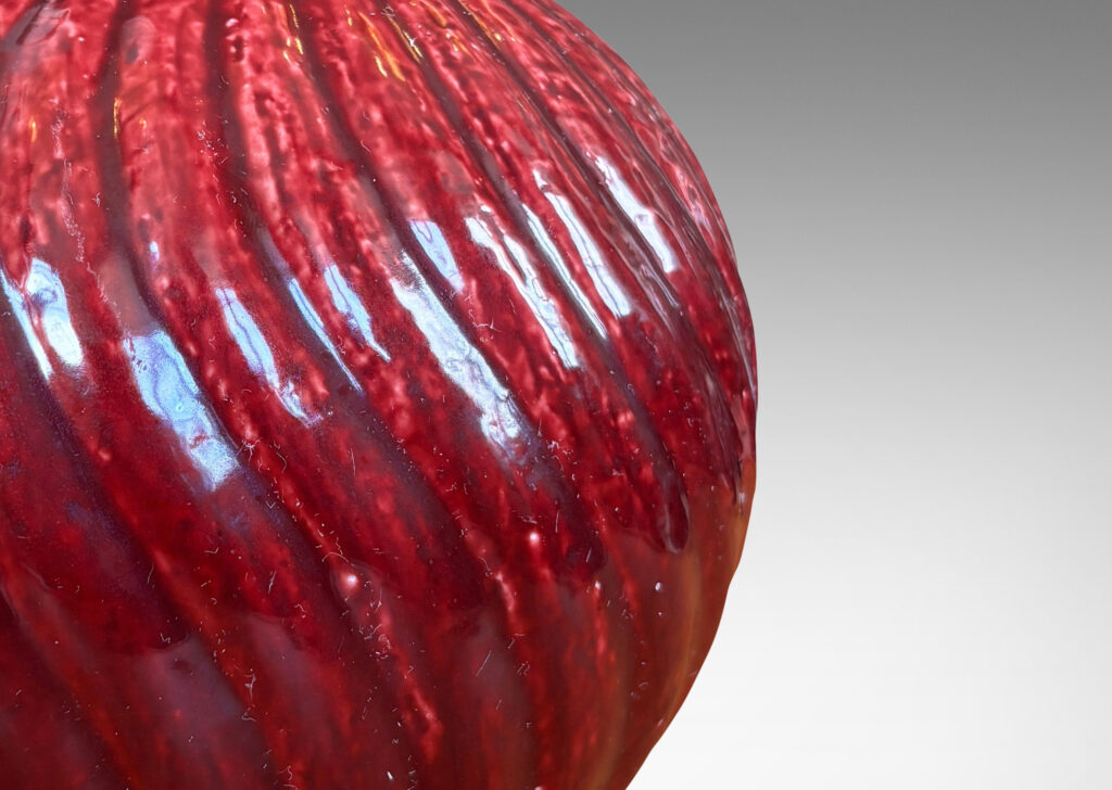 Gallery BAC globe form with spiraling vertical ribbing, in textured chamotte with a burgundy glaze