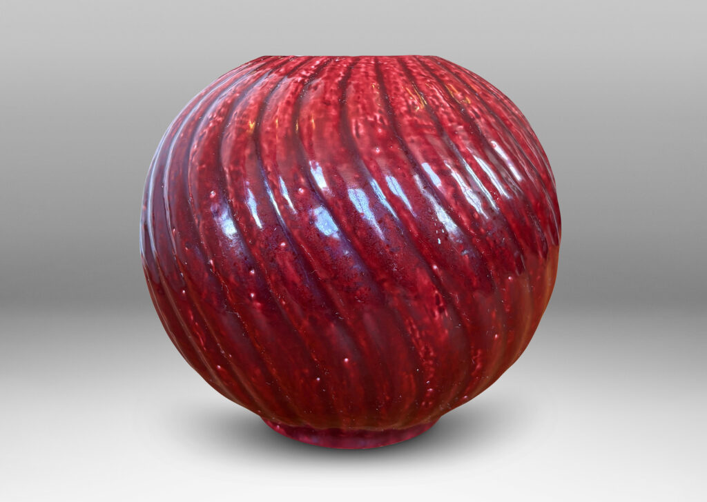 Gallery BAC globe form with spiraling vertical ribbing, in textured chamotte with a burgundy glaze