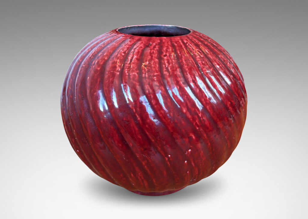 Gallery BAC globe form with spiraling vertical ribbing, in textured chamotte with a burgundy glaze