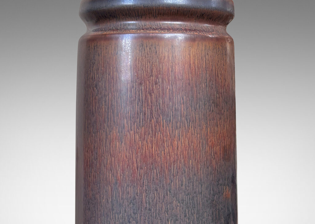 Gallery BAC cylindrical forms with exotic capped tops, glazed in a dark brown harefur