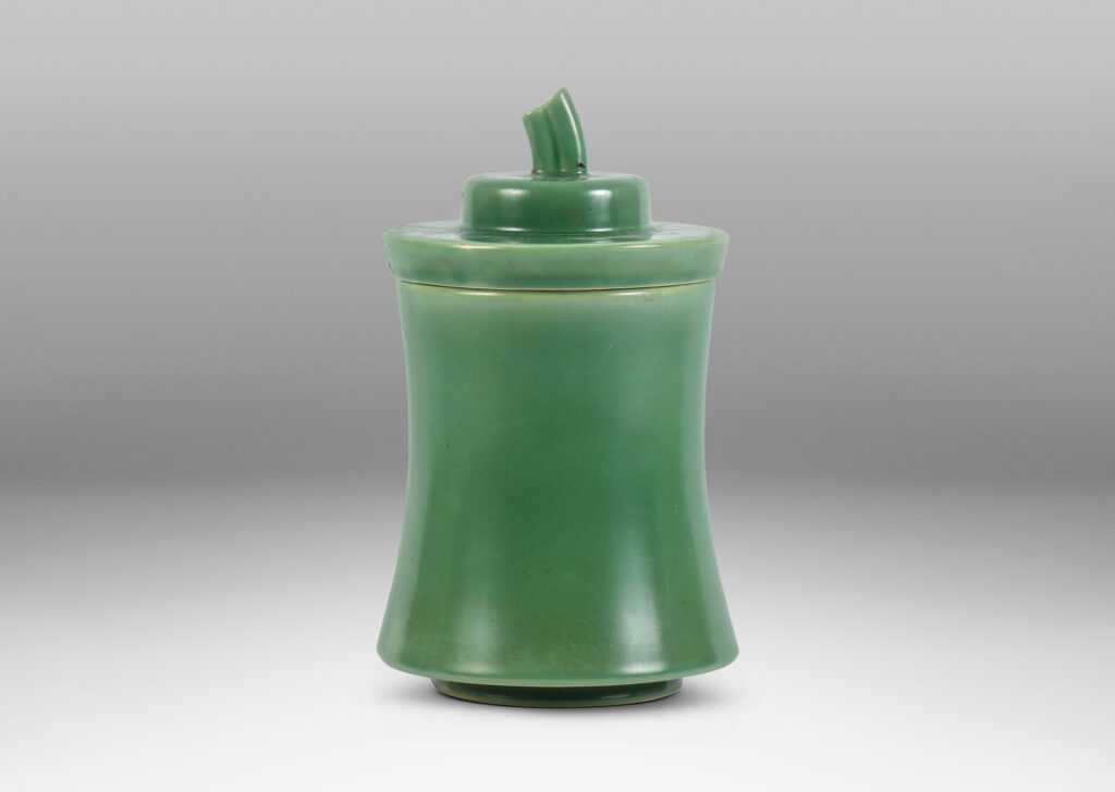 Gallery BAC concave-sided cylindrical form, with stepped lid and stem finial, glazed in a jade green tone