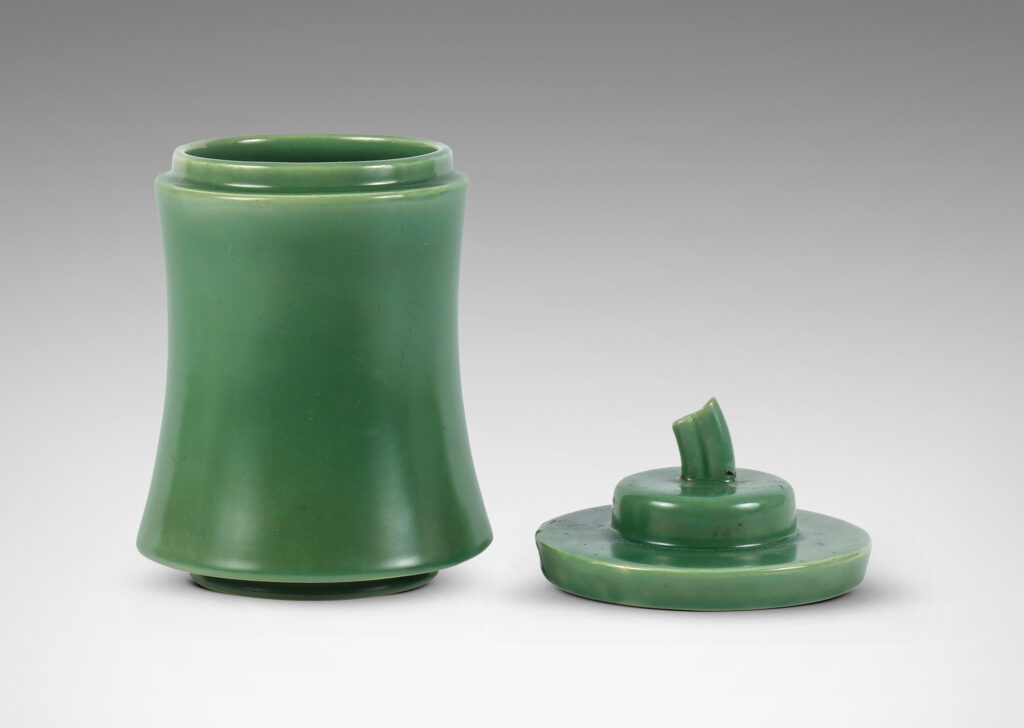 Gallery BAC concave-sided cylindrical form, with stepped lid and stem finial, glazed in a jade green tone