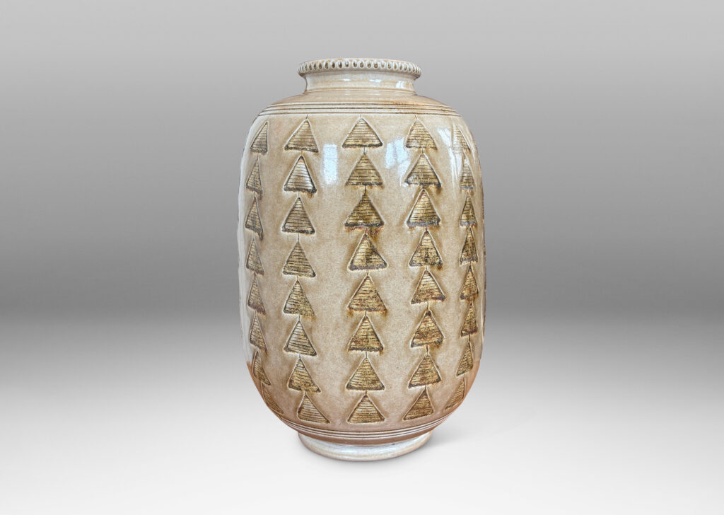 Gallery BAC large upright ovoid form decorated with carved rings and impressed triangle motifs, glazed in a pale topaz-brown