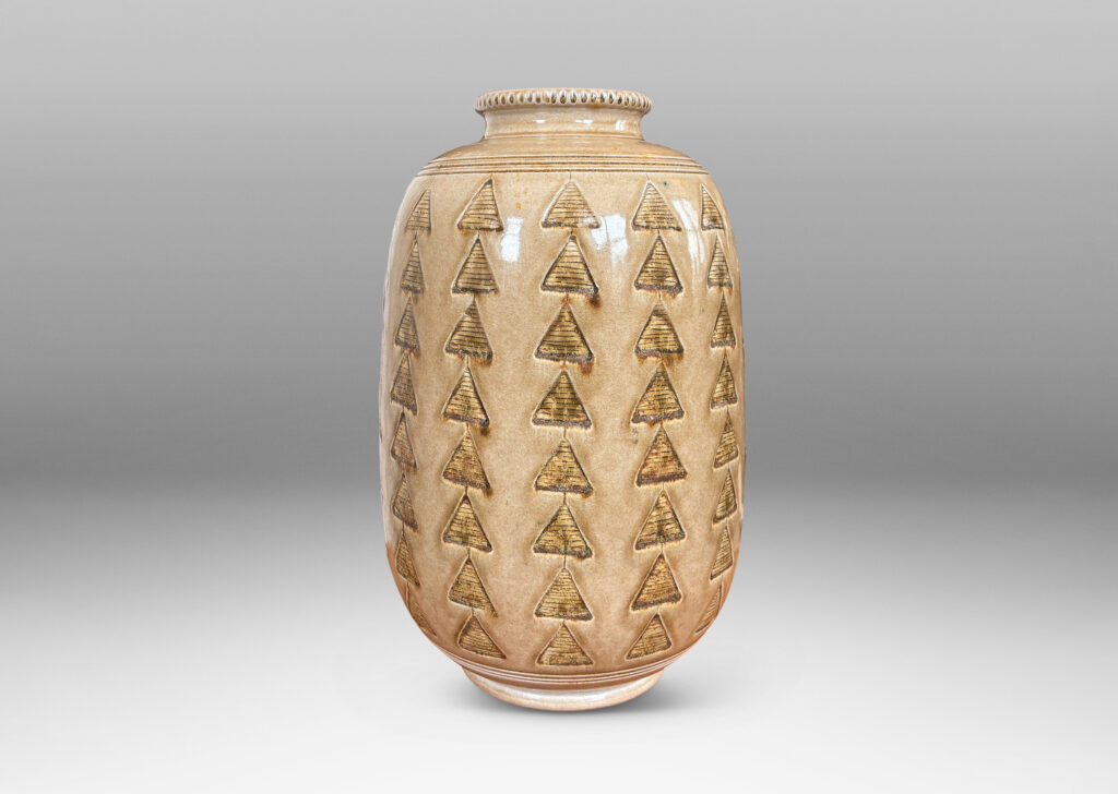 Gallery BAC large upright ovoid form decorated with carved rings and impressed triangle motifs, glazed in a pale topaz-brown