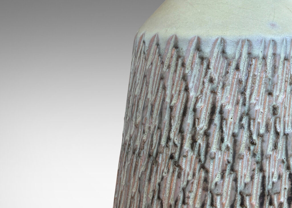 Gallery BAC flared drum forms with rustically textured sides and tall necks, glazed in a matte pale khaki tone; earthenware