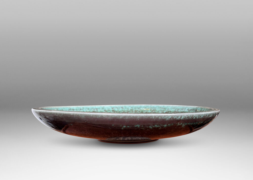 Gallery BAC beautifully sculpted wide shallow form with lip finished in carved hatch marks and a marvelous oxblood-celadon glaze