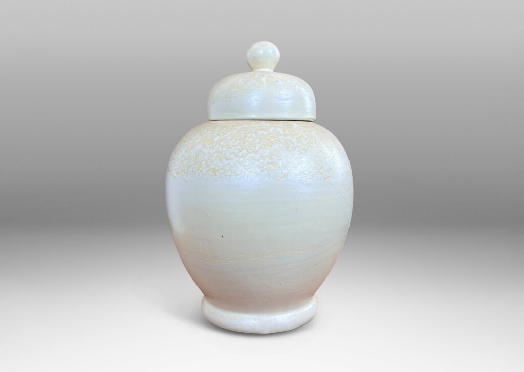 Gallery BAC softly modeled balloon-like form with dome lid and spherical finial, glazed in a pale yellow-ivory