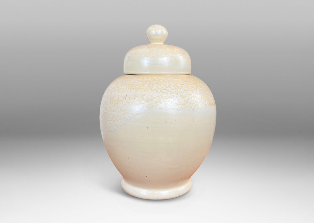 Gallery BAC softly modeled balloon-like form with dome lid and spherical finial, glazed in a pale yellow-ivory