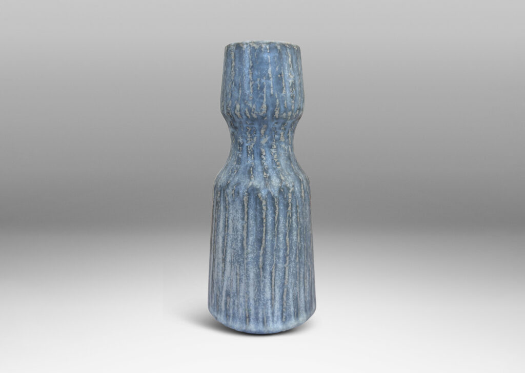 Gallery BAC notched form and another with a conical neck on a spherical body, both with carved surfaces glazed in a pale gray-blue