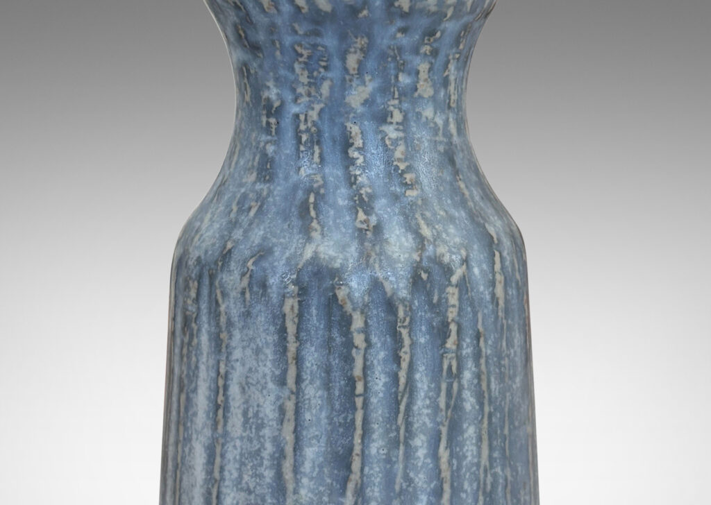 Gallery BAC notched form and another with a conical neck on a spherical body, both with carved surfaces glazed in a pale gray-blue