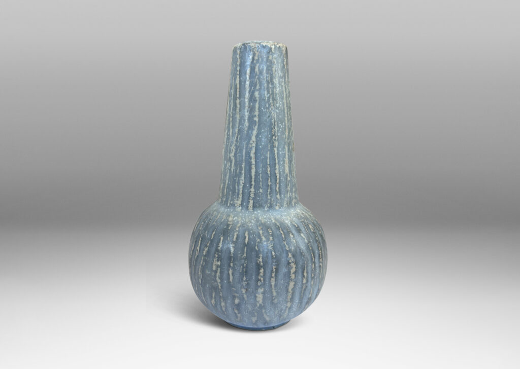 Gallery BAC notched form and another with a conical neck on a spherical body, both with carved surfaces glazed in a pale gray-blue