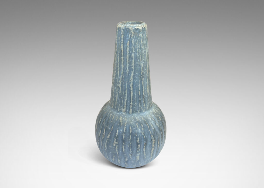 Gallery BAC notched form and another with a conical neck on a spherical body, both with carved surfaces glazed in a pale gray-blue