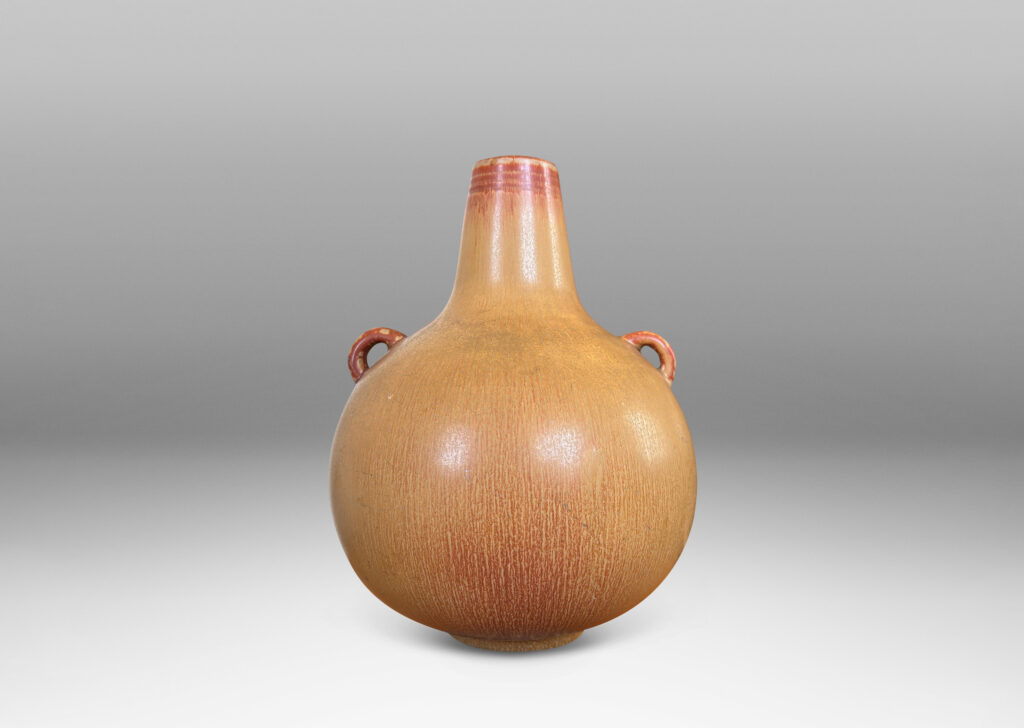 Gallery BAC globe form with sprouting neck and pair of ear-form handles, glazed in a flowing ochre tan-burnt sienna