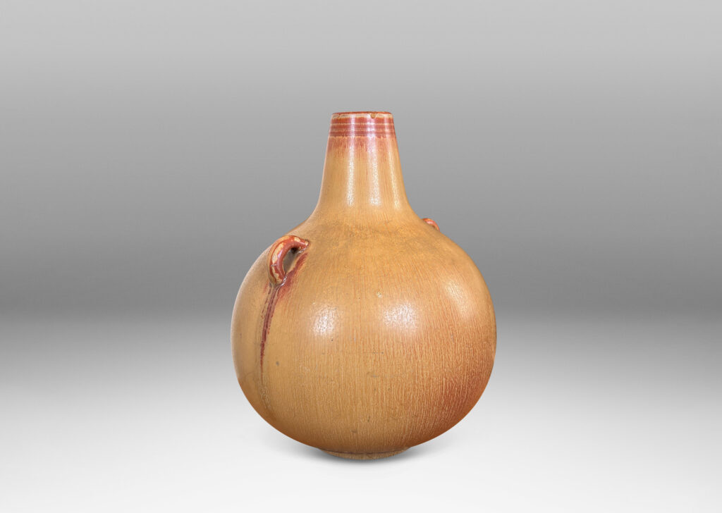 Gallery BAC globe form with sprouting neck and pair of ear-form handles, glazed in a flowing ochre tan-burnt sienna