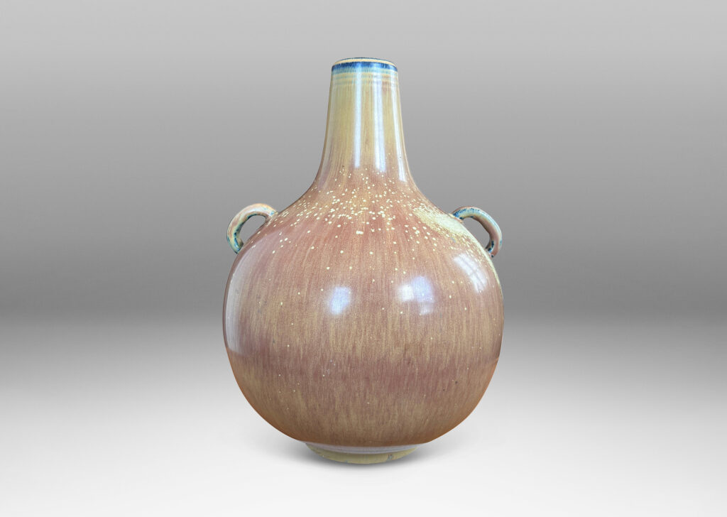 Gallery BAC globe form with sprouting neck and pair of ear-form handles, glazed in a flowing burnt sienna-ochre tan with pale speckling on shoulders