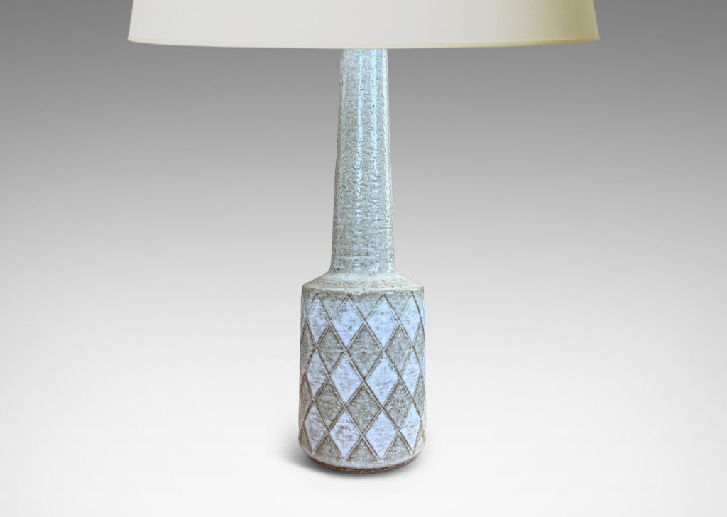 Gallery BAC drum form with carved harlequin design, and tall conical neck, glazed in pale gray with some diamond motifs in white