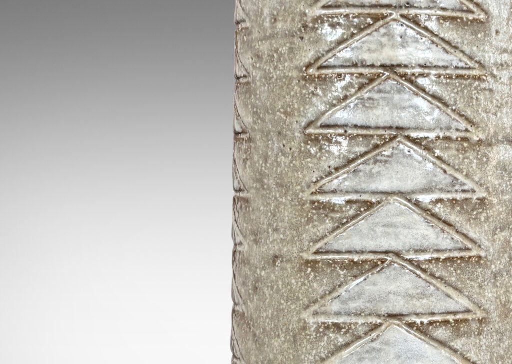 Gallery BAC cylindrical form with columns of carved triangle motifs, glazed in pale gray and white
