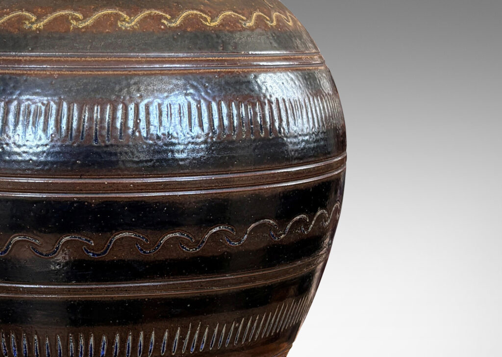 Gallery BAC tapered ovoid form with carved horizontal registers of alternating patterns, glazed in deep brown-black