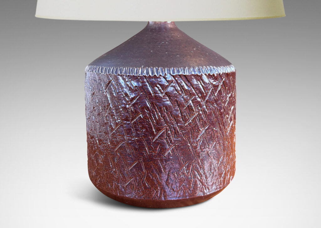 Gallery BAC drum form with encircling carved texture and whipstich pattern edging, glazed in a coppery red luster and brown