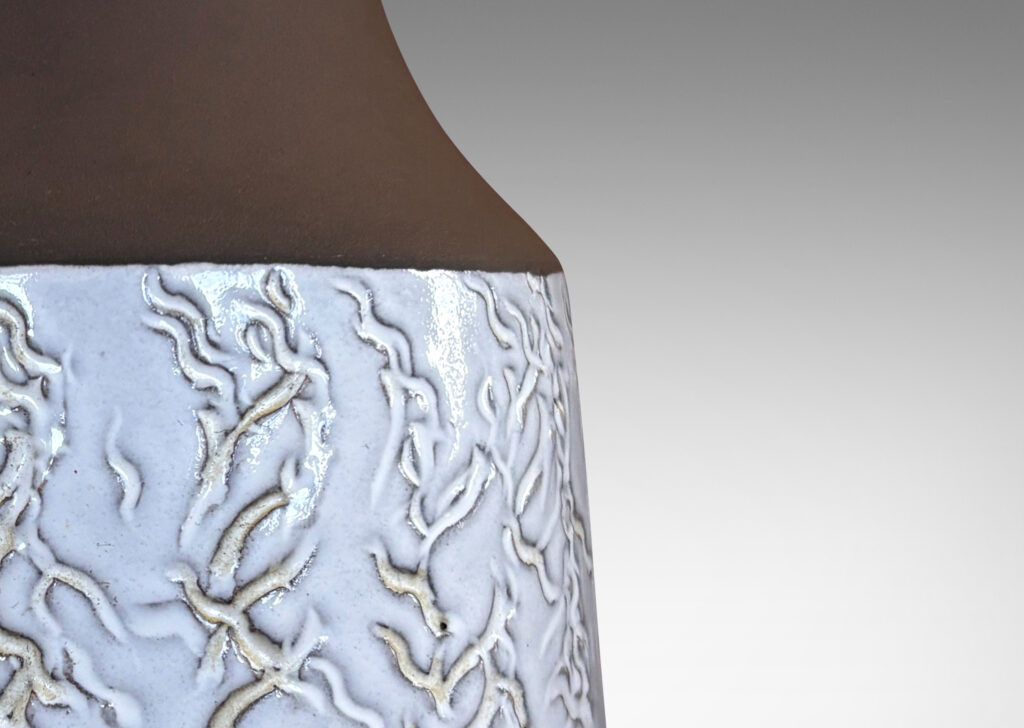 Gallery BAC slant-sided cylindrical forms with impressed texture and sprouting necks, glazed in shiny white and matte brown