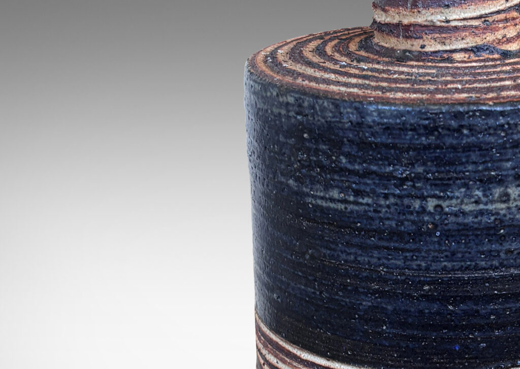 Gallery BAC slant-sided cylindrical forms with impressed texture and sprouting necks, glazed in shiny white and matte brown