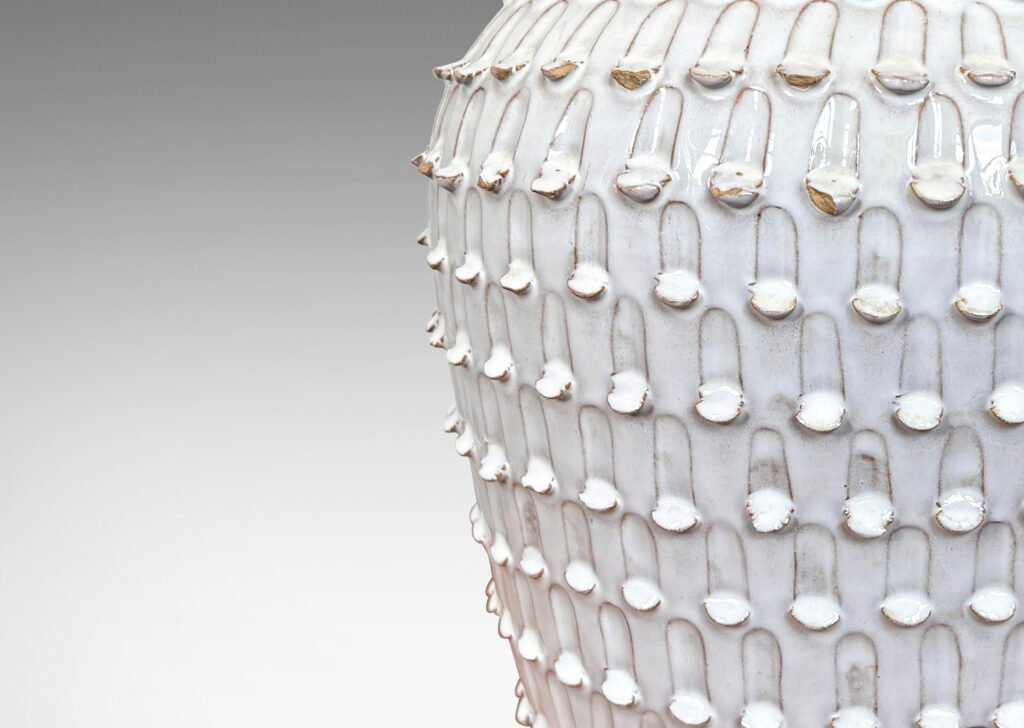 Gallery BAC wide, tapered form encircled in rows of carved strikes, glazed in glossy white