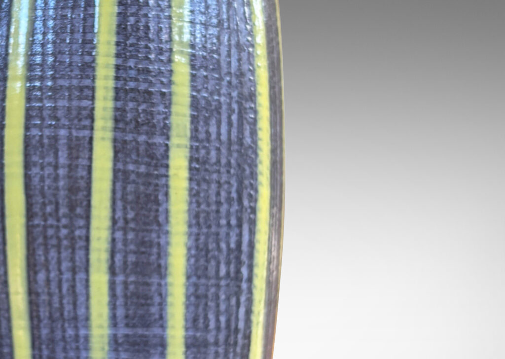 Gallery BAC swelling squared form with raked surface texture, glazed in a medium gray with yellow vertical pinstripes