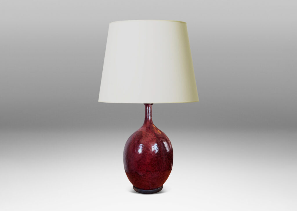 Gallery BAC ovoid form with sprouting attenuated neck, glazed in a flowing oxblood burgundy with red accents