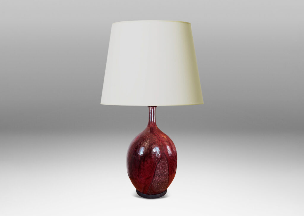 Gallery BAC ovoid form with sprouting attenuated neck, glazed in a flowing oxblood burgundy with red accents