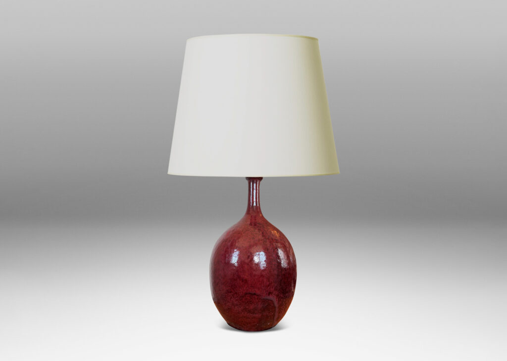 Gallery BAC ovoid form with sprouting attenuated neck, glazed in a flowing oxblood burgundy with red accents