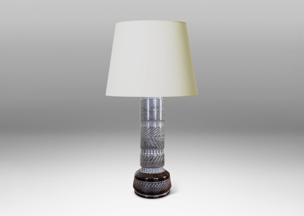 Gallery BAC totemic pillar form with turned and carved ornamental textures in a matte gray, with gloss black widened base