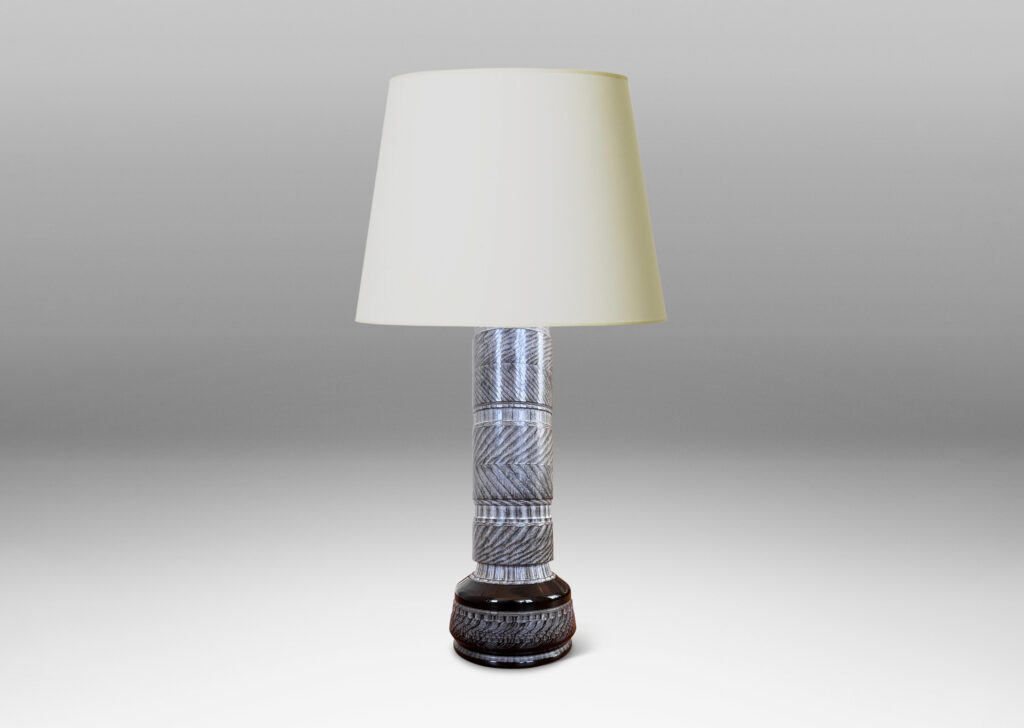 Gallery BAC totemic pillar form with turned and carved ornamental textures in a matte gray, with gloss black widened base