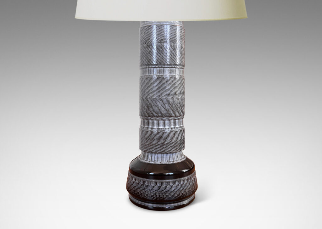 Gallery BAC totemic pillar form with turned and carved ornamental textures in a matte gray, with gloss black widened base