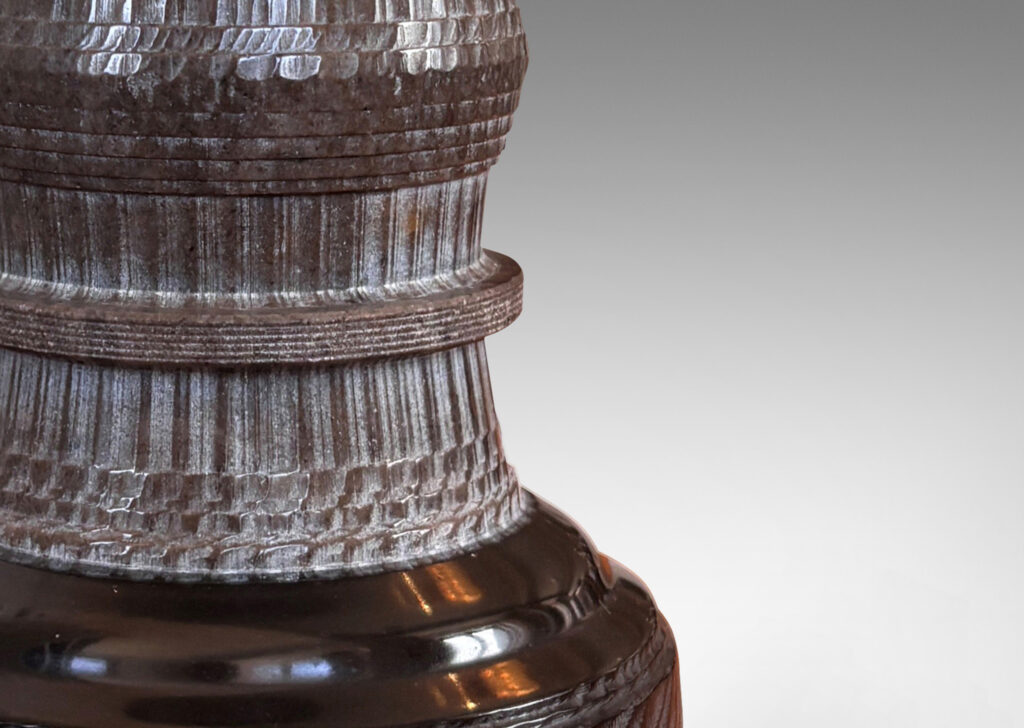 Gallery BAC totemic pillar form with turned and carved ornamental textures in a matte gray, with gloss black