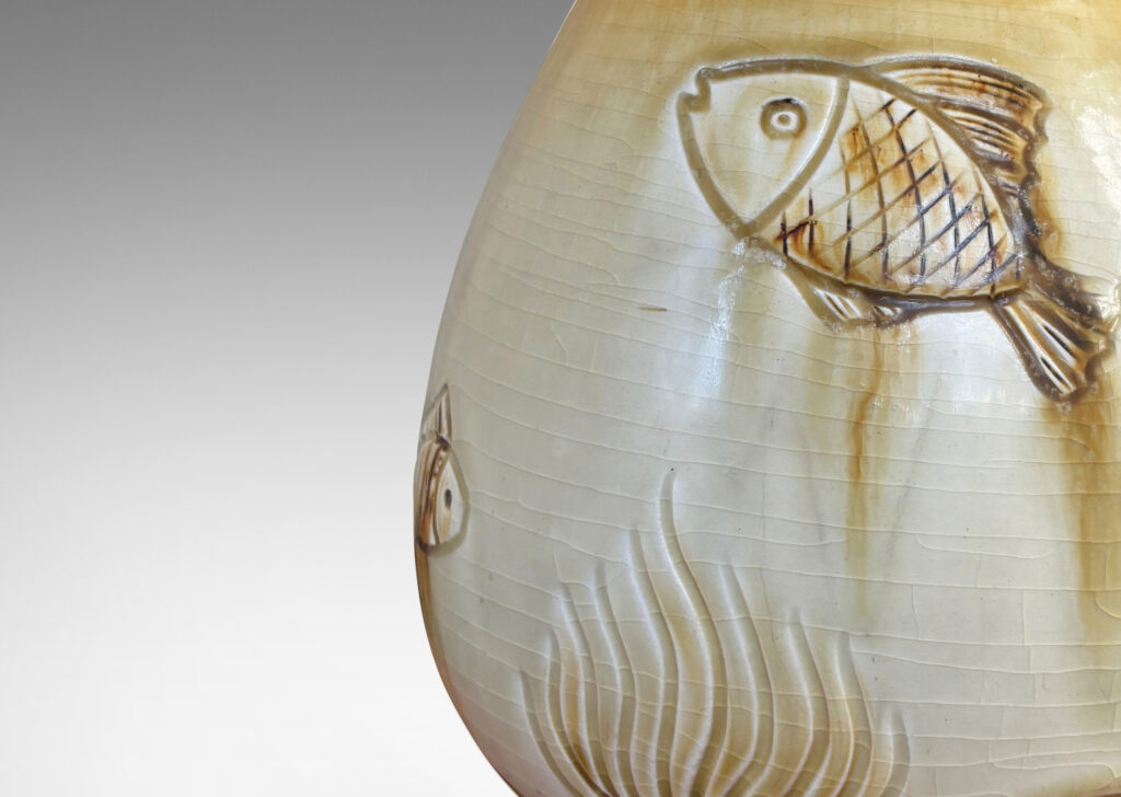 Gallery BAC tulip form with carved reliefs of goldfish and water flora, glazed in a thin amber-tan with brown accents