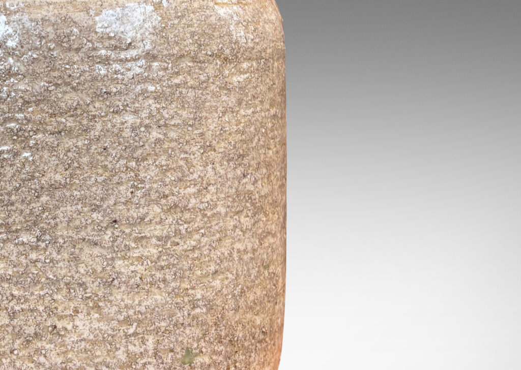 Gallery BAC rounded cylindrical form with textured surfacing, glazed in a pale sand tone with thin gray wash