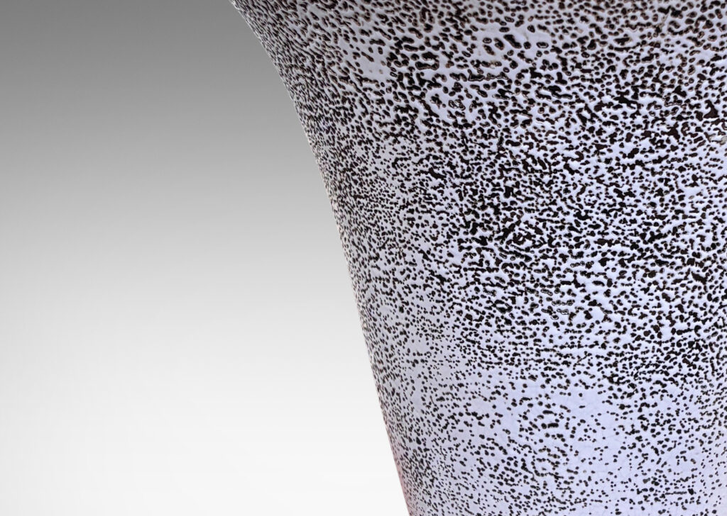 Gallery BAC lyre-silhouetted vase form on a flanged foot, glazed in white “crispé” glaze over matte brown