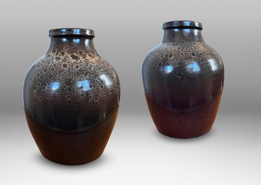 Gallery BAC tapered apple-like forms with wide necks, glazed in dark brown with mantles of lighter speckling