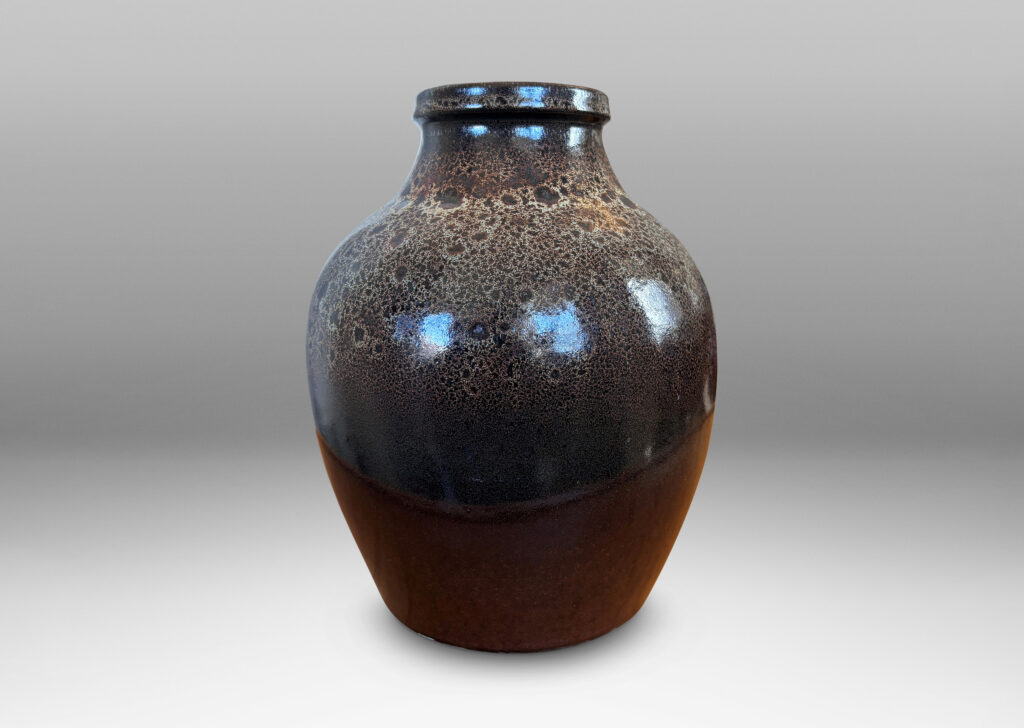 Gallery BAC tapered apple-like forms with wide necks, glazed in dark brown with mantles of lighter speckling