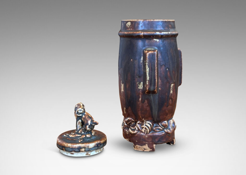 Gallery BAC swelling form with Chinese style articulated base, with relief foliate ornaments and doggie finial, glazed in a flowing matte brown