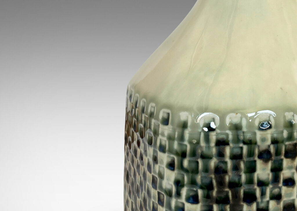 Gallery BAC square bottle-like form with checker reliefs and sprouting neck, glazed in ivory with flowing blue-gray