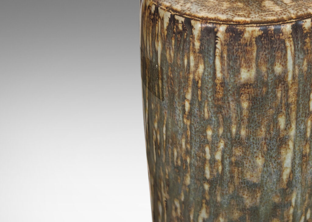 Gallery BAC swelling cylindrical forms with carved gouged surface and flowing brown glaze